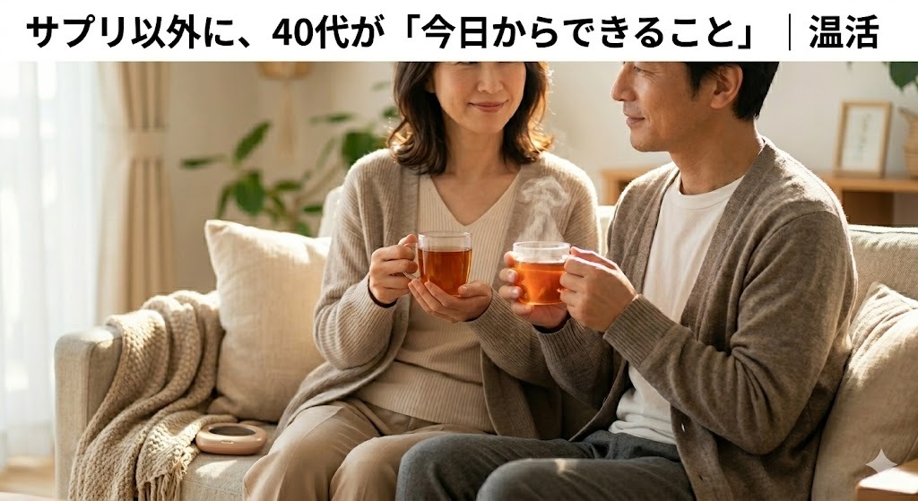40代の夫婦がリビングのソファでリラックスしながら温かい飲み物を手に笑顔で会話しているライフスタイル写真。温活や夫婦のコミュニケーションをイメージしている。